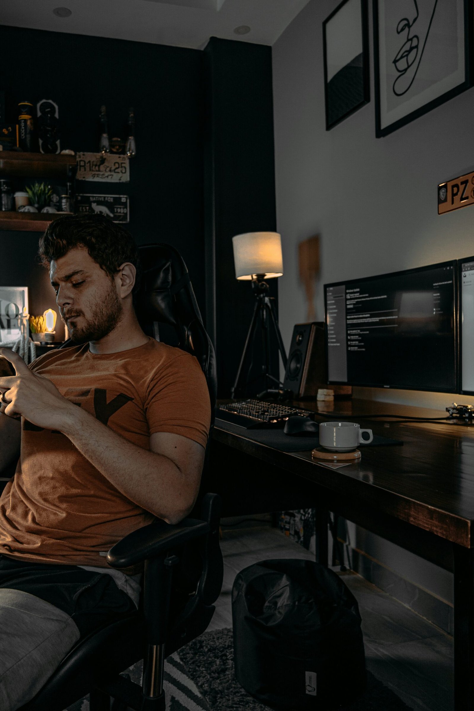 man in brown crew neck t-shirt sitting on black office rolling chair